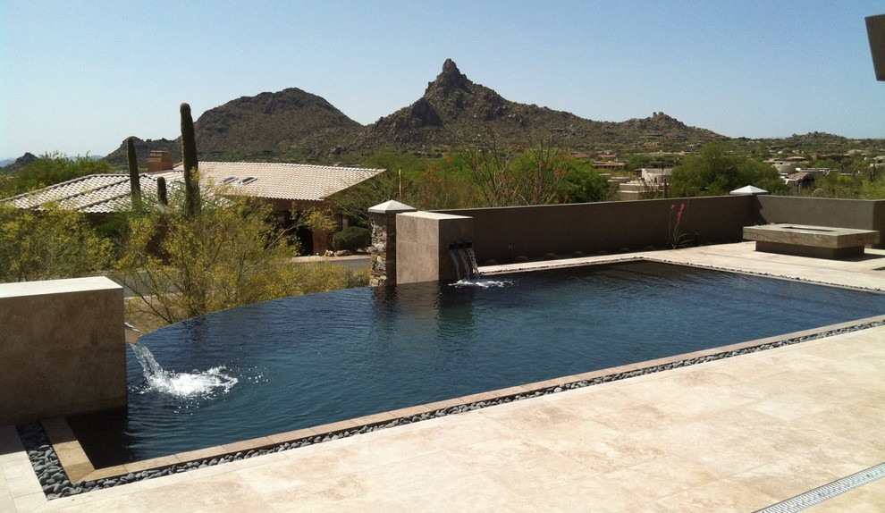 Ejemplo de piscina con fuente infinita de estilo americano de tamaño medio a medida en patio trasero con suelo de baldosas