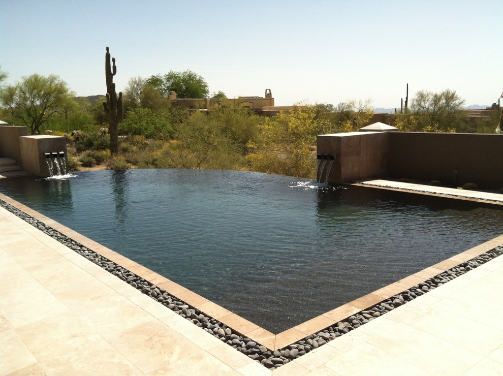 Cette image montre une piscine à débordement et arrière sud-ouest américain de taille moyenne et sur mesure avec un point d'eau et du carrelage.
