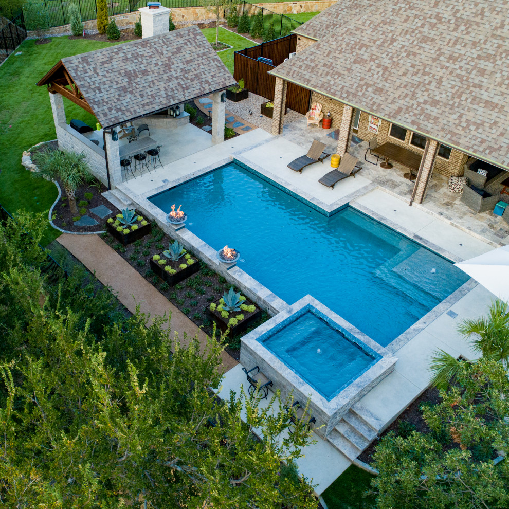 Ejemplo de piscina con fuente alargada tradicional renovada de tamaño medio a medida en patio trasero con adoquines de piedra natural