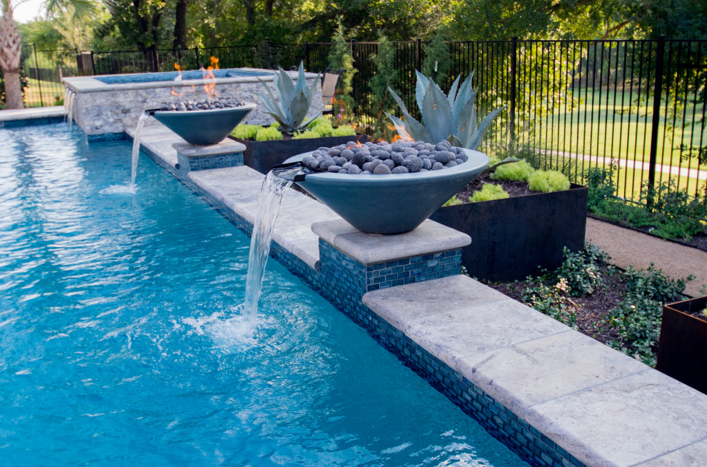 Ejemplo de piscina con fuente alargada clásica renovada de tamaño medio a medida en patio trasero con adoquines de piedra natural