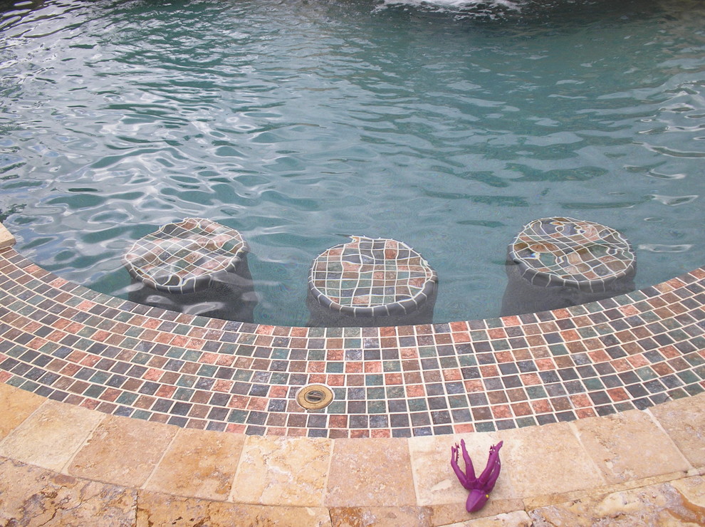Design ideas for a large world-inspired back custom shaped natural swimming pool in Miami with a water feature.