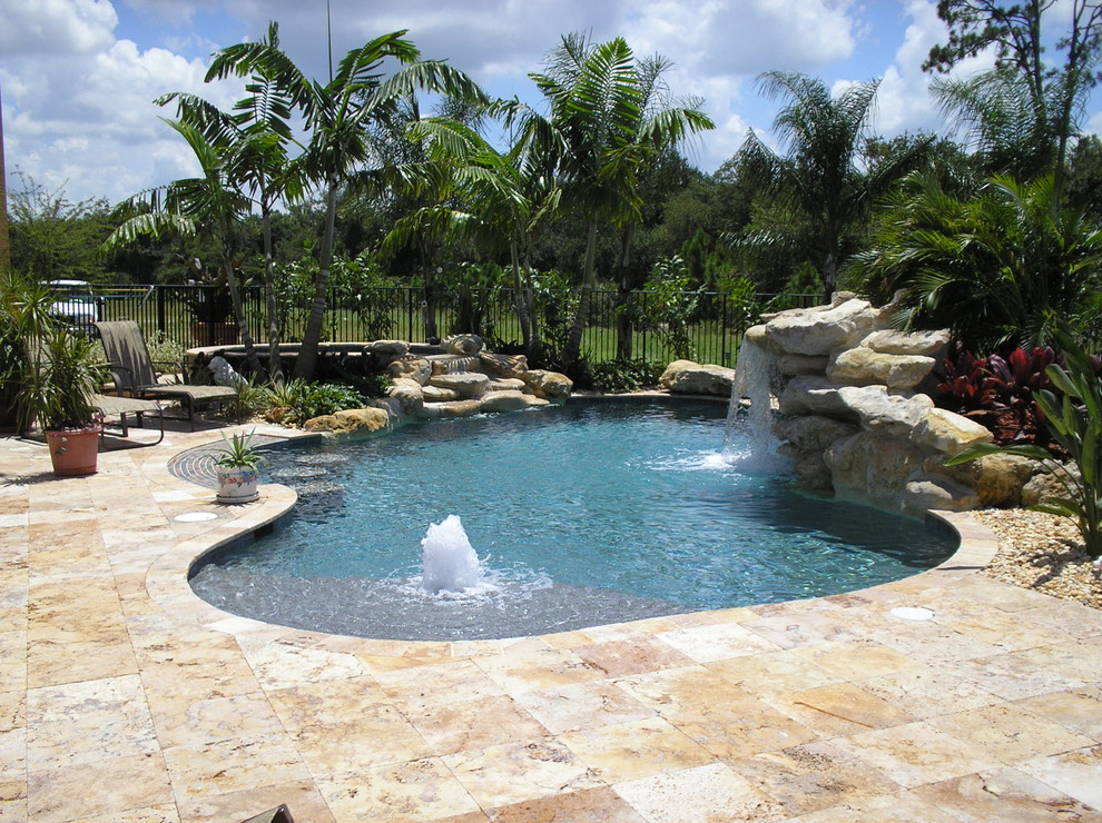 Idée de décoration pour une grande piscine naturelle et arrière ethnique sur mesure avec un point d'eau.