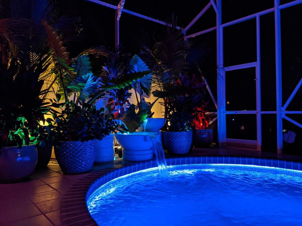 Diseño de piscina ecléctica de tamaño medio tipo riñón en patio trasero con paisajismo de piscina y losas de hormigón