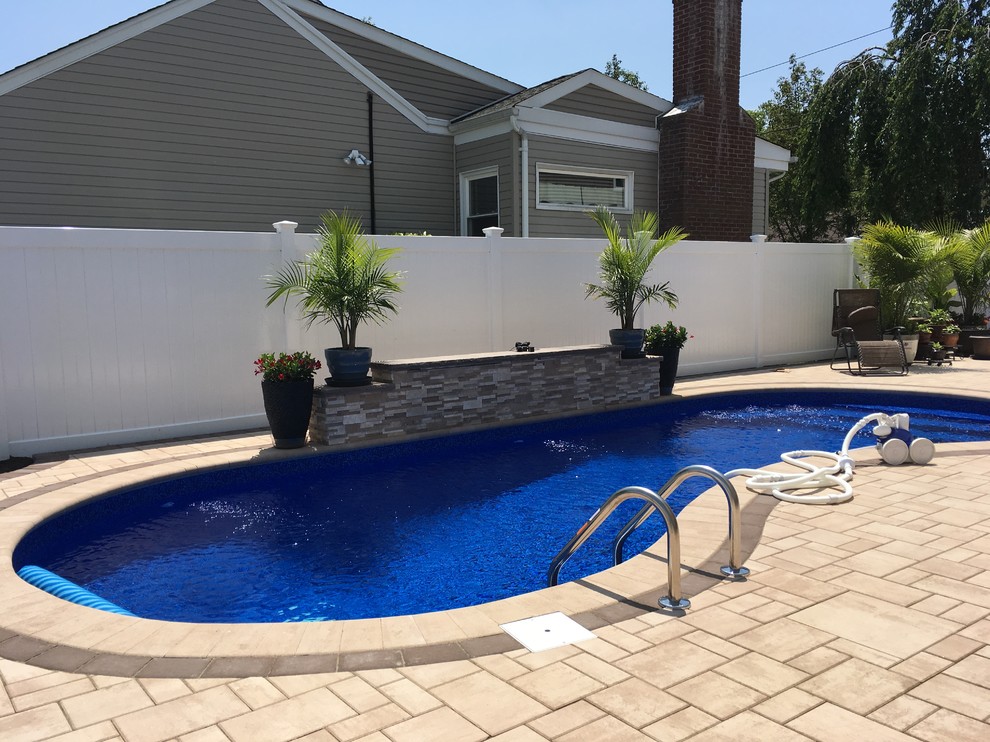 Modelo de piscina elevada clásica de tamaño medio tipo riñón en patio trasero con suelo de baldosas