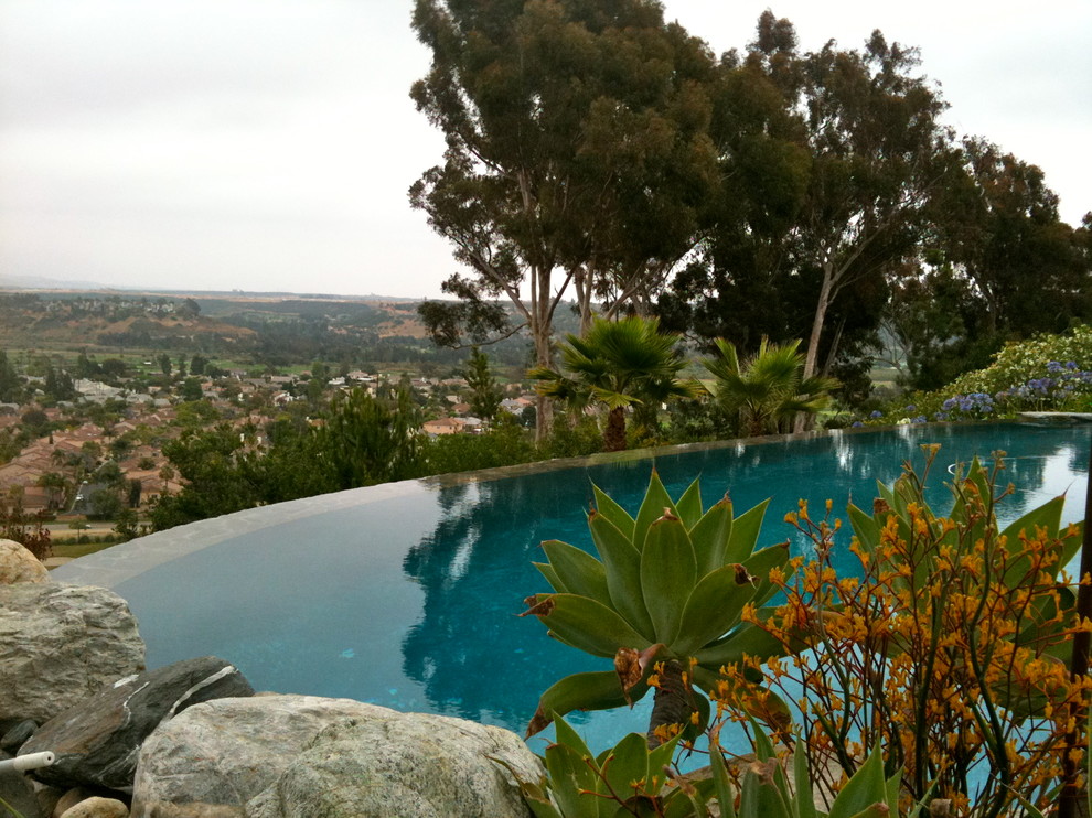 Großer Mediterraner Pool hinter dem Haus in individueller Form mit Natursteinplatten in San Diego