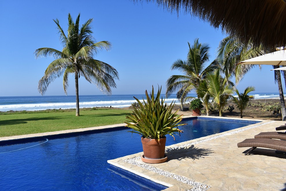 Großer Pool hinter dem Haus in L-Form mit Natursteinplatten in San Diego