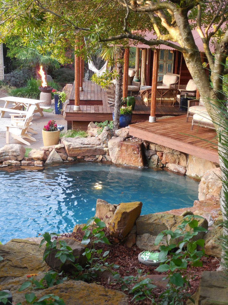 Inspiration for a huge tropical backyard stamped concrete and custom-shaped natural pool fountain remodel in Dallas