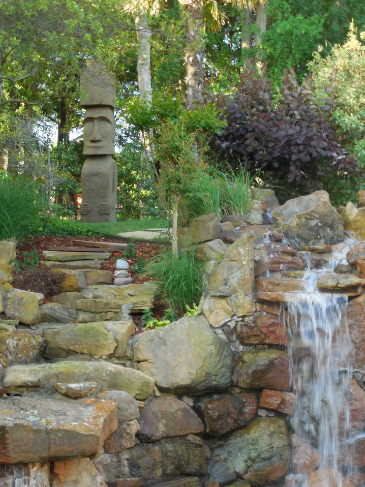 Photo of a huge tropical backyard water fountain landscape in Dallas.
