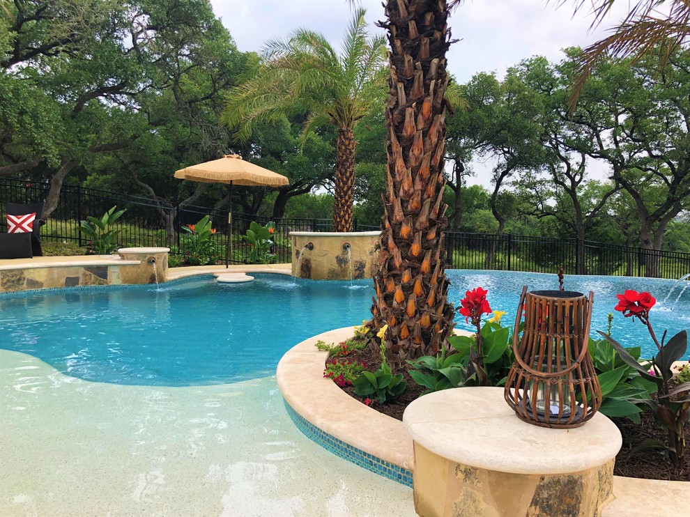 Diseño de piscina con fuente natural exótica de tamaño medio tipo riñón en patio trasero con entablado