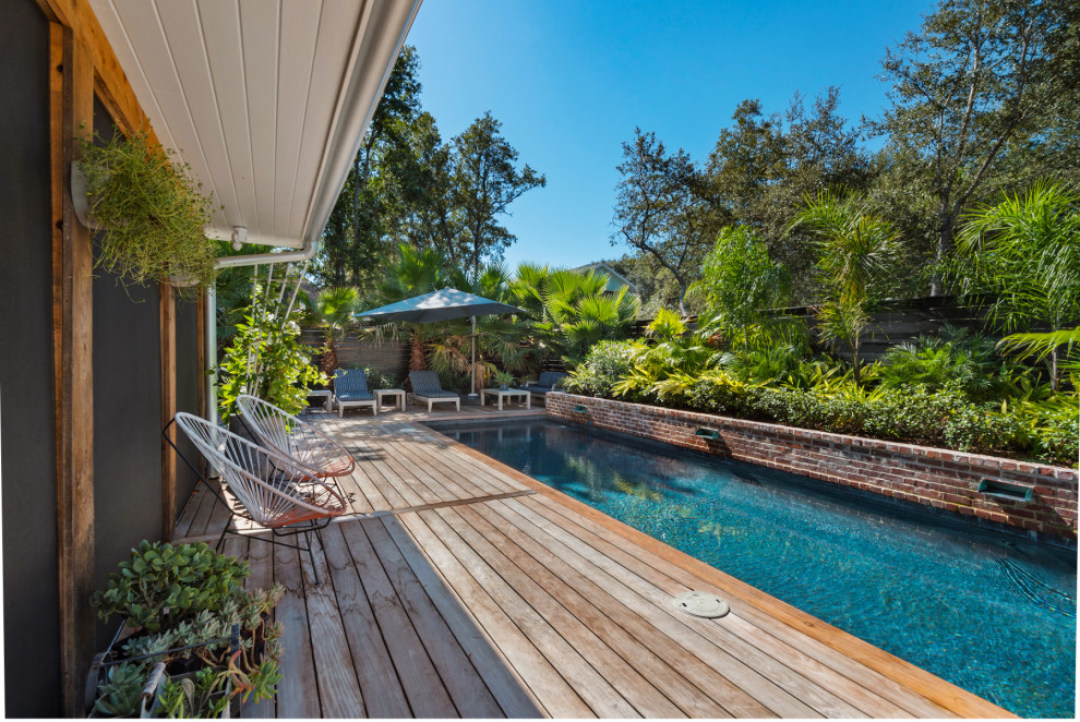 Immagine di una piccola piscina tropicale rettangolare nel cortile laterale con pedane
