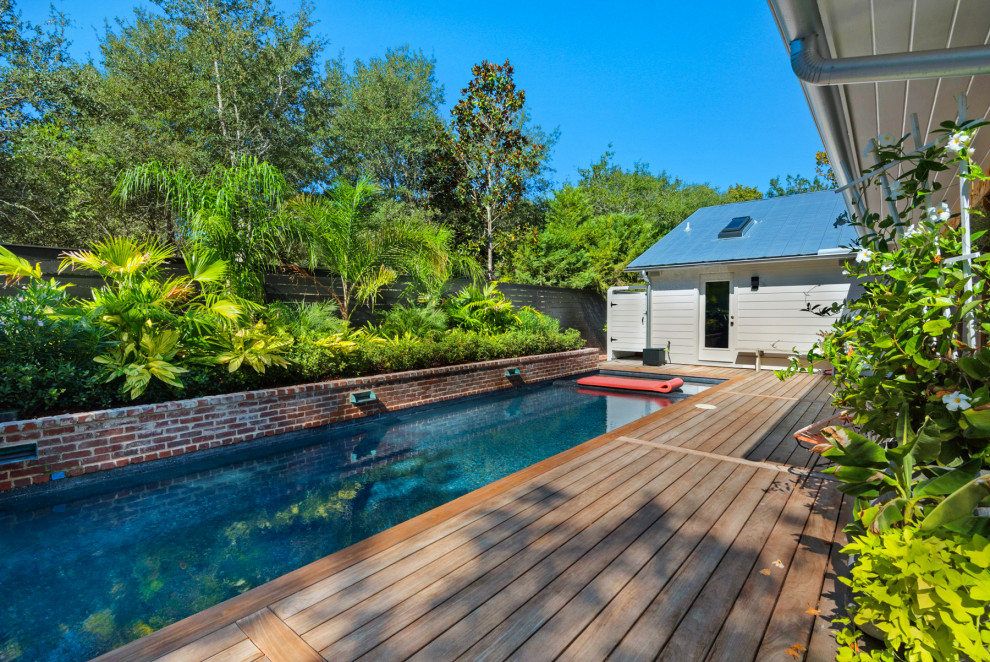 Foto di una piccola piscina tropicale rettangolare nel cortile laterale con pedane