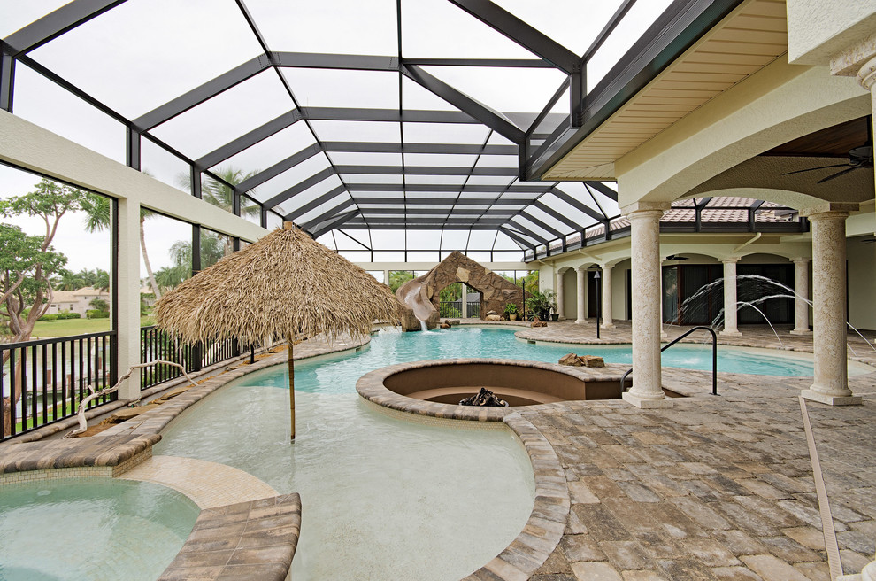 Bild på en tropisk anpassad pool, med vattenrutschkana