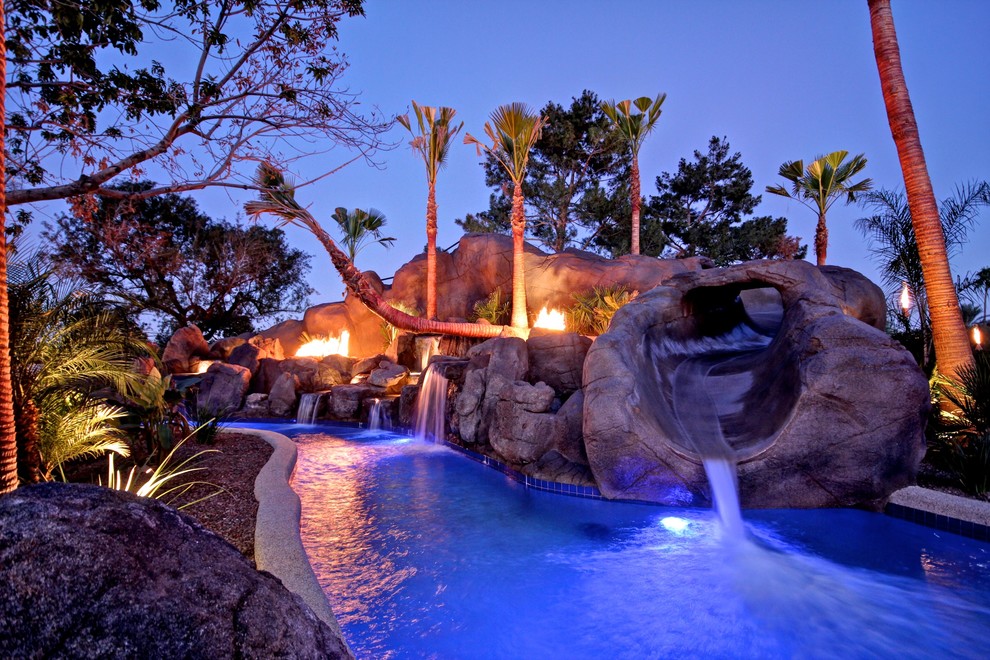 フェニックスにあるラグジュアリーな巨大なトロピカルスタイルのおしゃれな裏庭プール (ウォータースライダー、タイル敷き) の写真