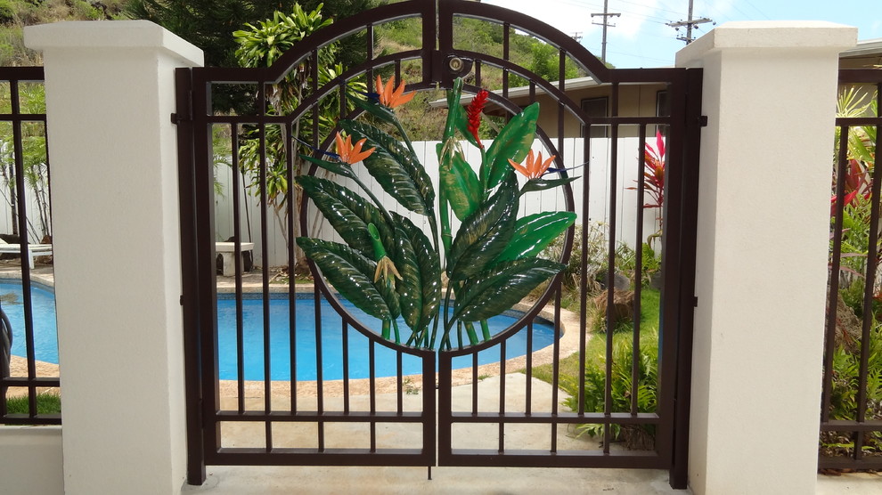 Ispirazione per una grande piscina monocorsia tropicale a "C" dietro casa con pavimentazioni in pietra naturale
