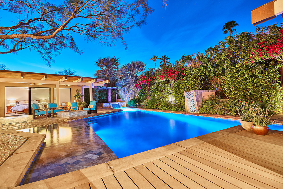 Large island style custom-shaped pool fountain photo in Los Angeles with decking