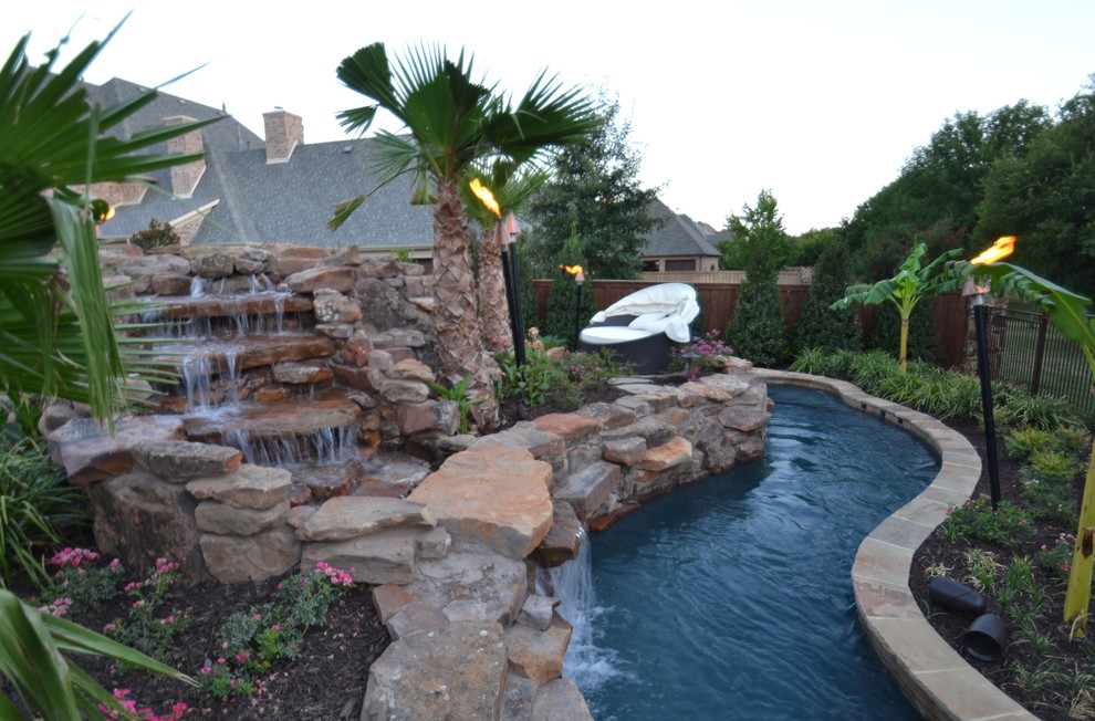 Foto de piscina con fuente natural exótica grande a medida en patio trasero con adoquines de piedra natural