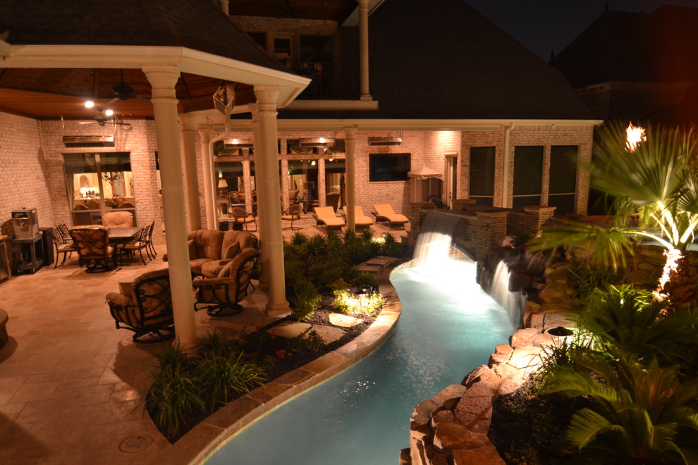 Esempio di una grande piscina naturale tropicale personalizzata dietro casa con fontane e pavimentazioni in pietra naturale