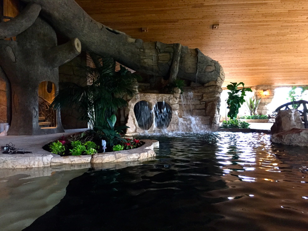 Modelo de piscina con fuente alargada exótica de tamaño medio a medida en patio trasero con adoquines de piedra natural