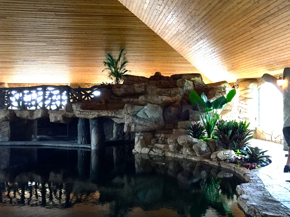 Diseño de piscina con fuente alargada exótica de tamaño medio a medida en patio trasero con adoquines de piedra natural