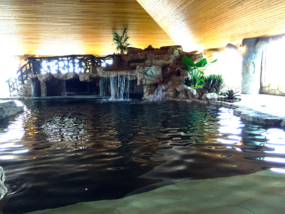 Mittelgroßes Sportbecken hinter dem Haus in individueller Form mit Wasserspiel und Natursteinplatten in Orlando