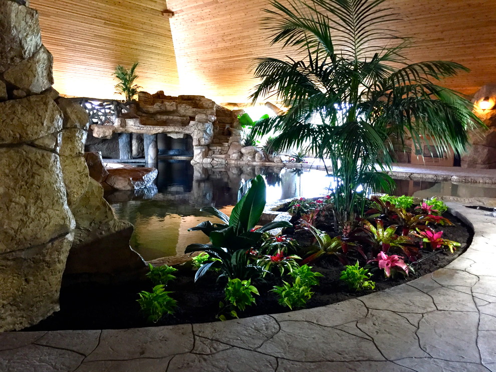 Esempio di una piscina monocorsia tropicale personalizzata di medie dimensioni e dietro casa con fontane e pavimentazioni in pietra naturale