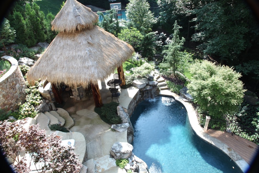 На фото: большой бассейн произвольной формы на заднем дворе в морском стиле с фонтаном с