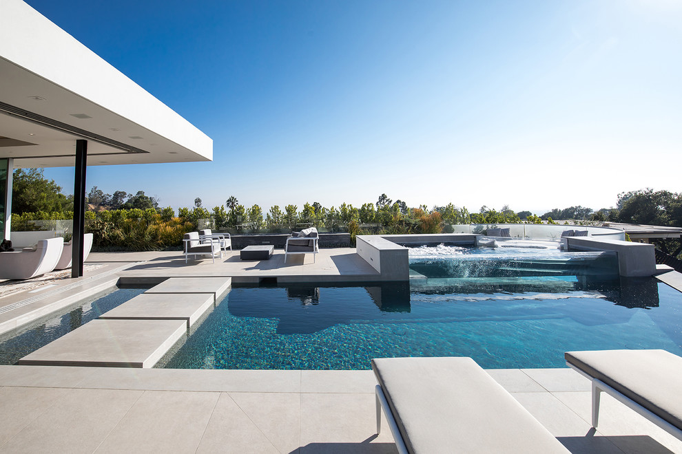 Свежая идея для дизайна: огромный наземный, прямоугольный бассейн на заднем дворе в стиле модернизм с джакузи и покрытием из плитки - отличное фото интерьера