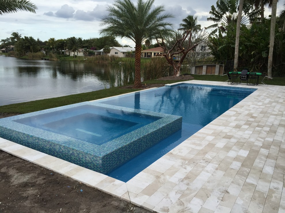 На фото: большой бассейн на боковом дворе в стиле модернизм с покрытием из каменной брусчатки с