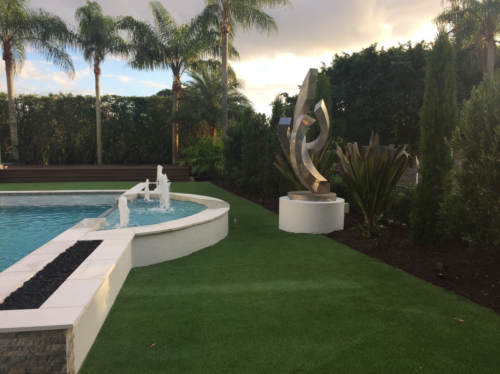 Imagen de piscina moderna en patio lateral con adoquines de piedra natural