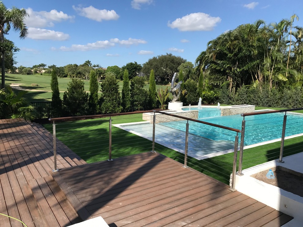 Inspiration for a large contemporary side swimming pool in Miami with natural stone paving.