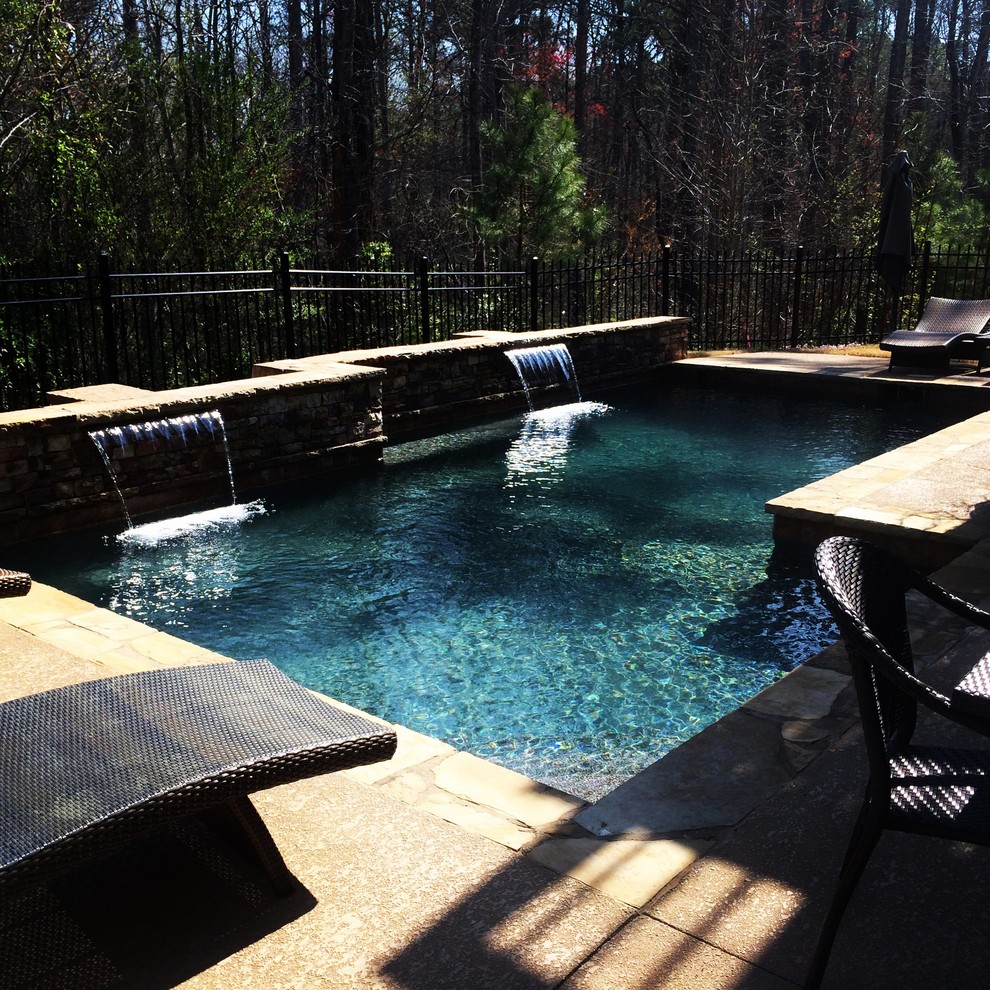 Esempio di una piccola piscina naturale chic personalizzata dietro casa con fontane e pedane