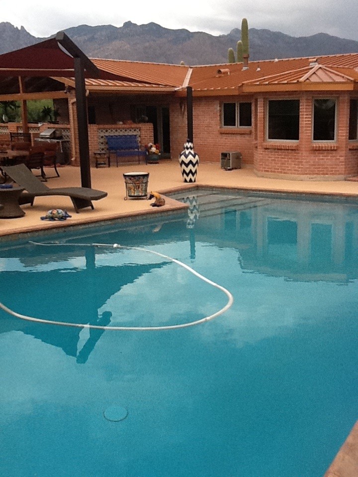 Foto de piscina con fuente mediterránea de tamaño medio en forma de L en patio trasero con suelo de baldosas