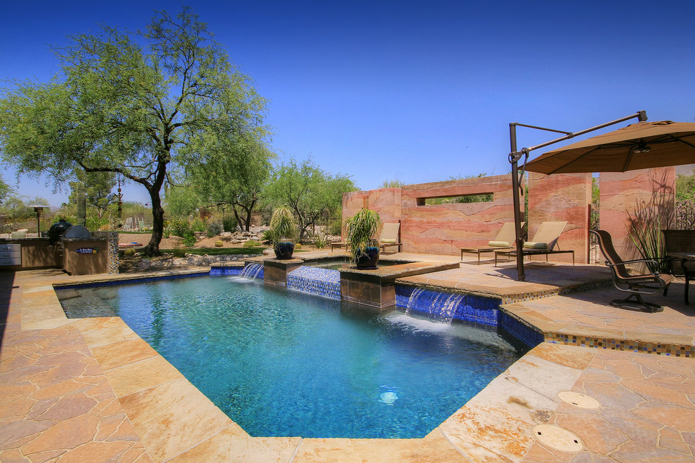 Idee per una grande piscina naturale american style personalizzata dietro casa con fontane e pavimentazioni in pietra naturale