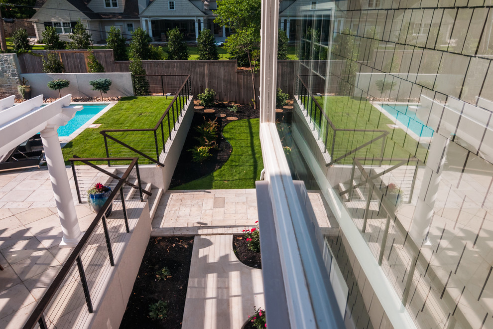 Modelo de piscinas y jacuzzis alargados contemporáneos grandes rectangulares en patio trasero con adoquines de hormigón