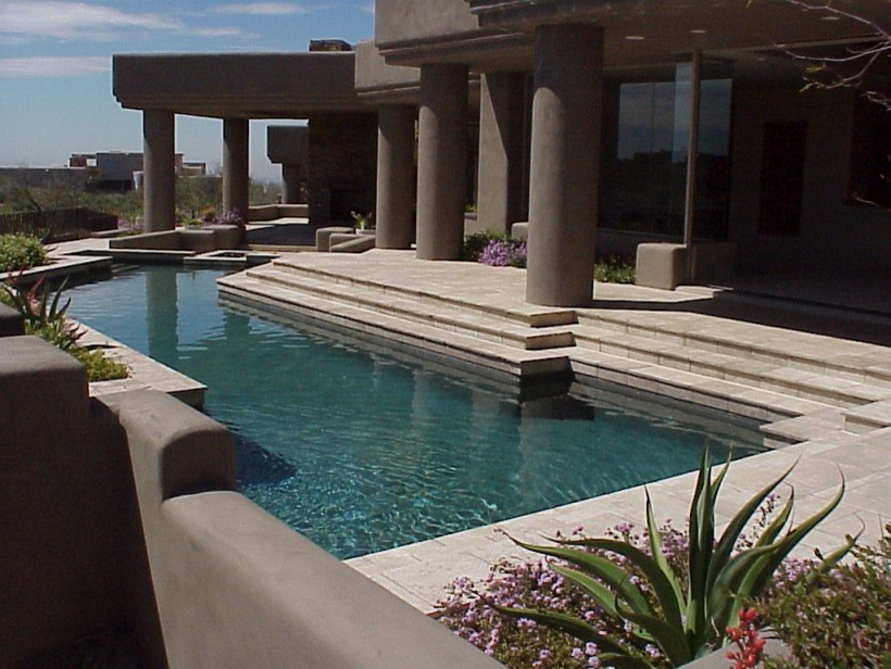Imagen de piscina de estilo americano extra grande en forma de L en patio trasero con suelo de baldosas
