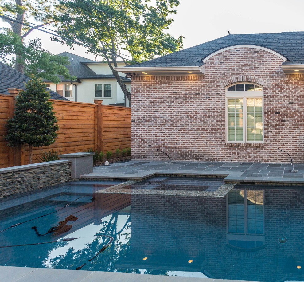 Foto di una piscina monocorsia contemporanea personalizzata dietro casa e di medie dimensioni con una vasca idromassaggio e pavimentazioni in pietra naturale