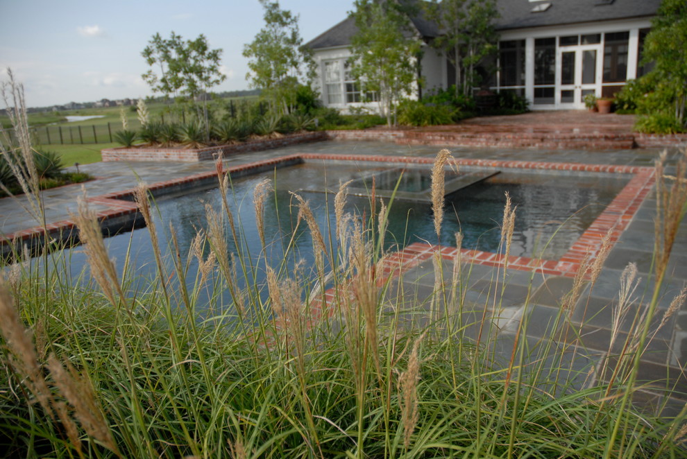 Idee per una piscina a sfioro infinito country personalizzata di medie dimensioni e dietro casa con una vasca idromassaggio e pavimentazioni in pietra naturale