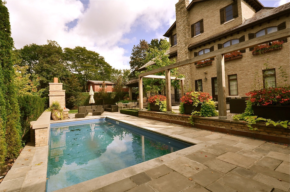 Exempel på en mellanstor medelhavsstil rektangulär pool på baksidan av huset, med en fontän och naturstensplattor