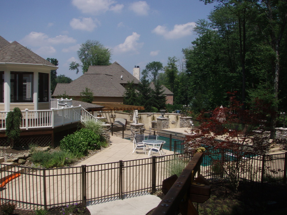 Imagen de casa de la piscina y piscina mediterránea de tamaño medio rectangular en patio trasero con losas de hormigón