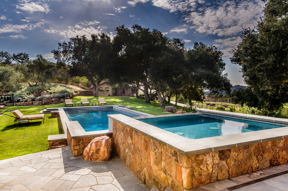 Design ideas for a large back rectangular lengths hot tub in San Diego with natural stone paving.