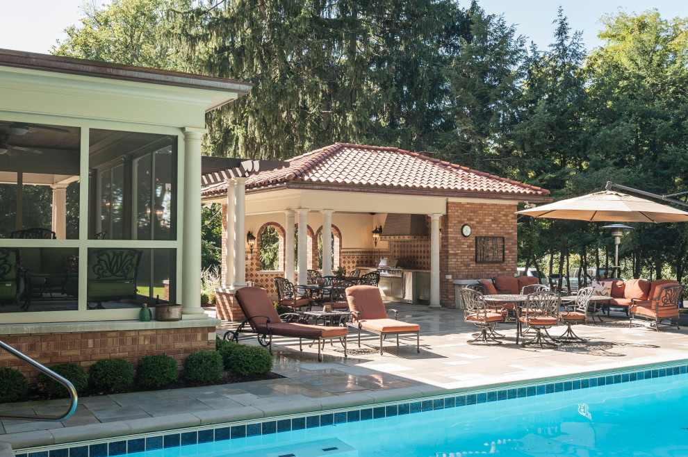 Стильный дизайн: большой естественный, прямоугольный бассейн на заднем дворе в средиземноморском стиле с домиком у бассейна и покрытием из каменной брусчатки - последний тренд