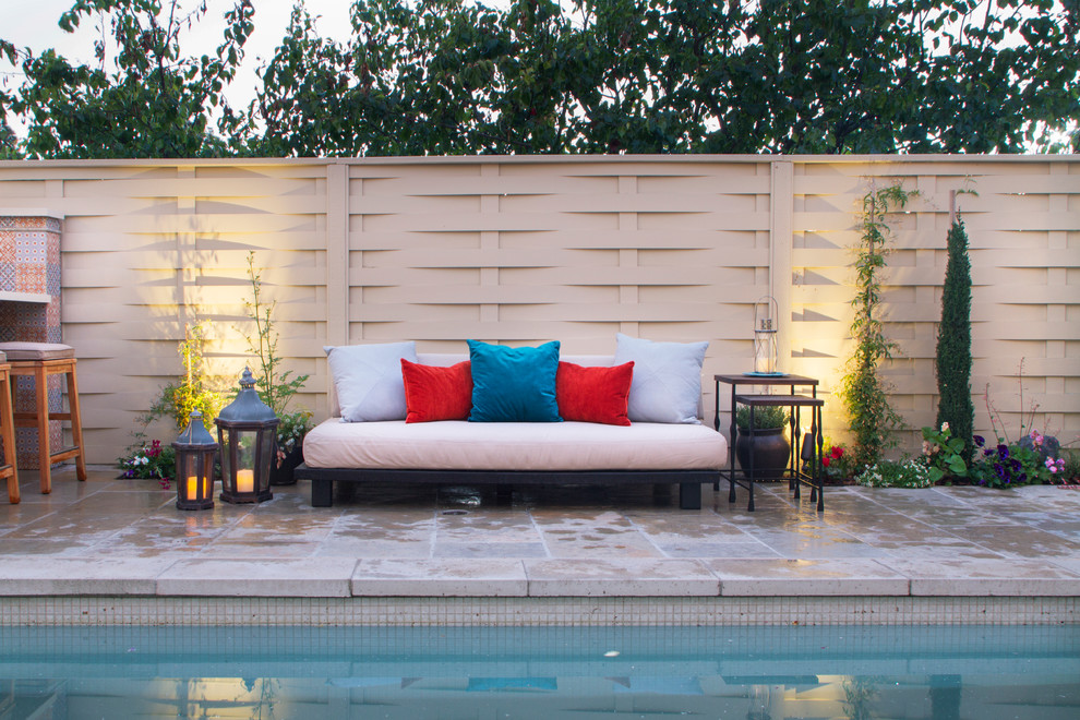 Modelo de casa de la piscina y piscina alargada mediterránea rectangular en patio trasero con adoquines de piedra natural