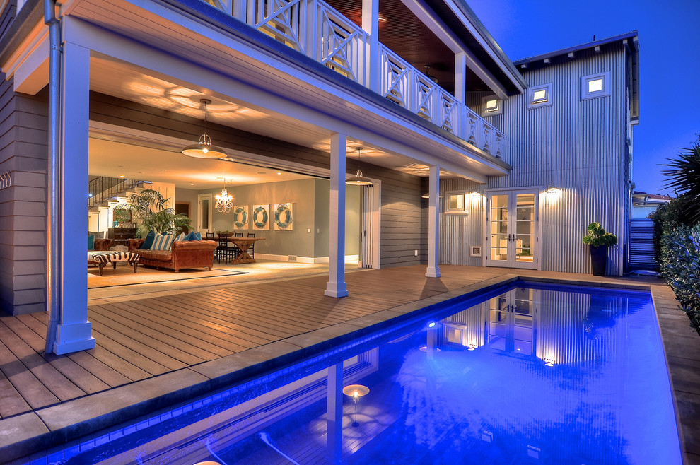 Ejemplo de piscinas y jacuzzis alargados costeros de tamaño medio rectangulares en patio trasero con entablado