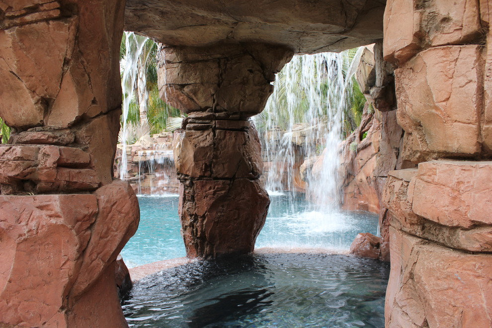 Esempio di una grande piscina naturale tropicale personalizzata dietro casa con fontane