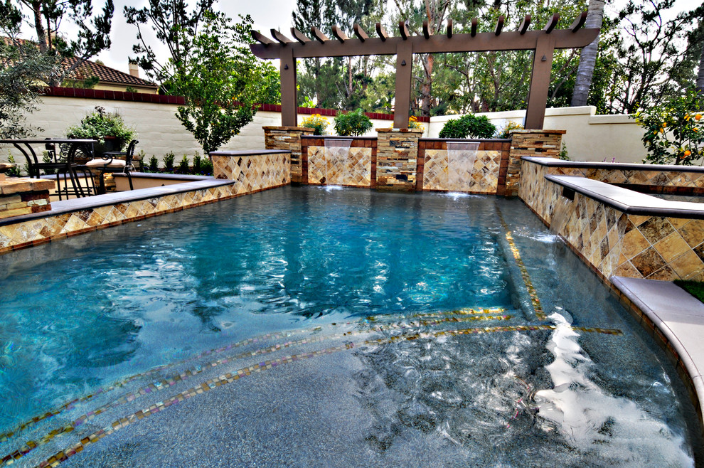 Foto di una piccola piscina mediterranea rettangolare dietro casa con fontane e lastre di cemento