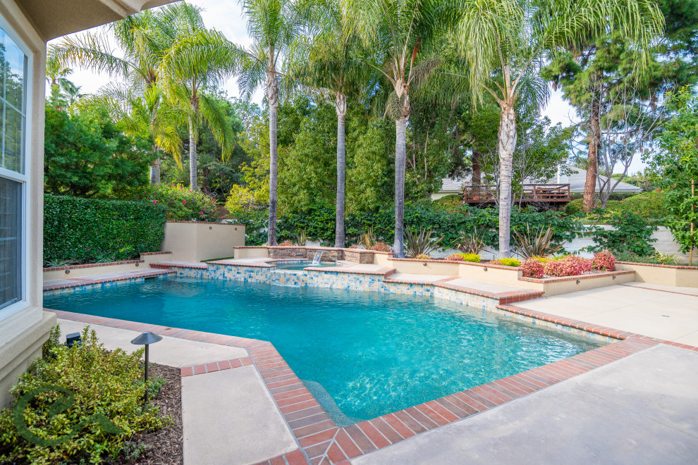 Mittelgroßer Mediterraner Pool hinter dem Haus in individueller Form mit Betonplatten in Orange County