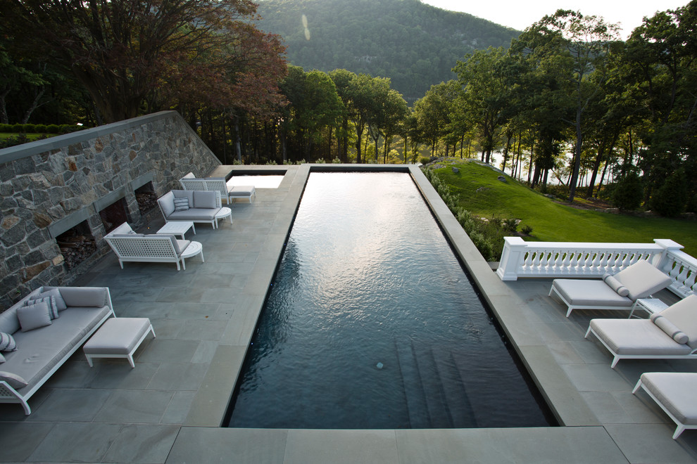 Diseño de piscinas y jacuzzis alargados de estilo americano grandes rectangulares en patio lateral con adoquines de piedra natural
