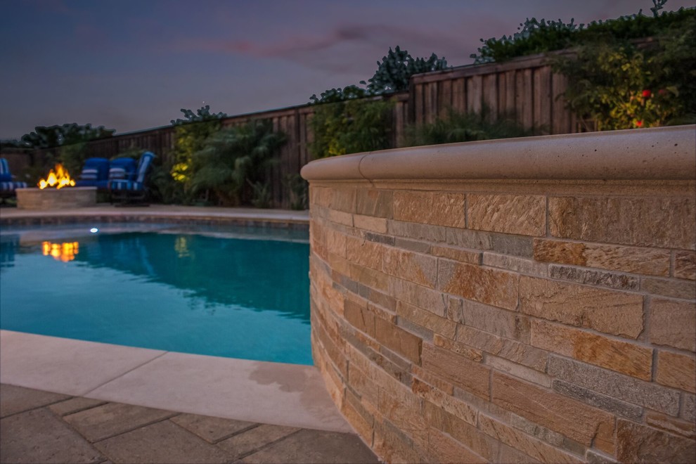 Foto di una piscina monocorsia tradizionale rotonda di medie dimensioni e dietro casa con una vasca idromassaggio e pavimentazioni in pietra naturale