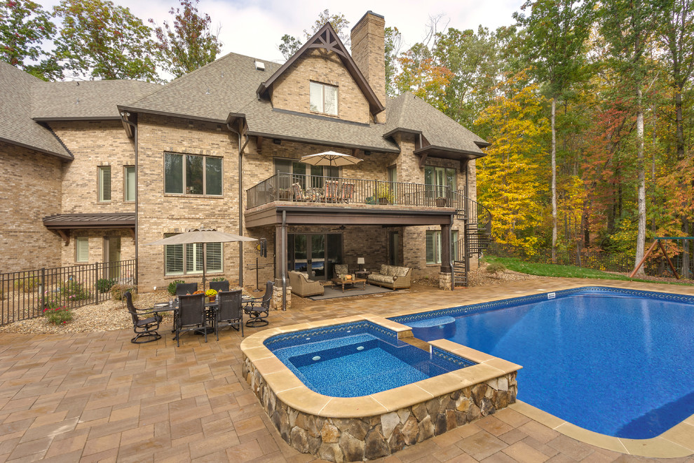 Example of a classic backyard tile and rectangular lap hot tub design in Charlotte