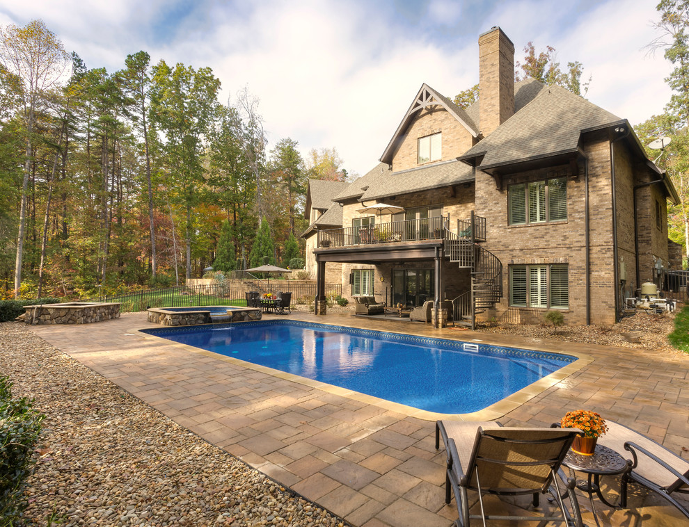 Diseño de piscinas y jacuzzis alargados clásicos rectangulares en patio trasero con suelo de baldosas